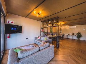 a living room with two couches and a flat screen tv at Le Bezz Guesthouse in Ballito