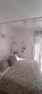 a bedroom with a bed with a canopy and a window at Appartamento Onda Marina in Polignano a Mare