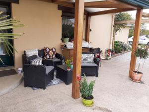 a covered patio with two chairs and a table at chambre à la campagne in Baulon +4 photos