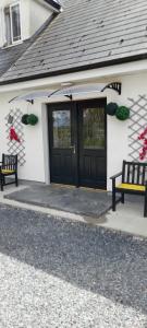 a house with two benches in front of a door at Annaswood B&B in Cahir