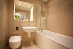 a bathroom with a sink and a toilet and a bath tub at Citystay Living - The Vie in Cambridge +5 photos