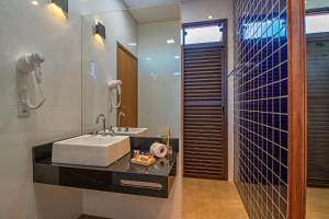 a bathroom with a sink and a mirror at Cassorova Hotel Boutique in Brotas