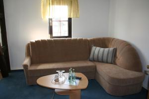 a living room with a couch and a table at Gasthaus & Hotel Zur Linde in Hermsdorf