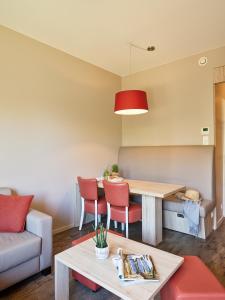 Holiday Suites Westende في ميدل كيرك: غرفة معيشة مع طاولة وكراسي
