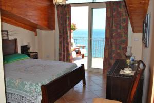 レトイアンニにあるFondaco Parrino Mareのベッドルーム1室(ベッド1台付)、海を望むバルコニーが備わります。