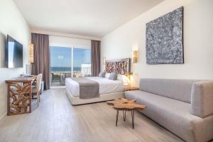 a hotel room with a bed and a couch at Zahara Beach & Spa by QHotels - Adults Recommended in Zahara de los Atunes