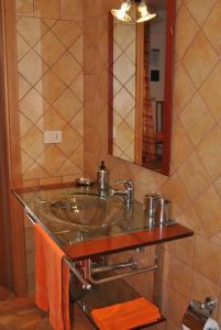 a bathroom with a glass sink and a mirror at Fondaco Parrino Mare in Letojanni