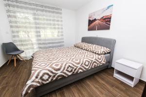 a bedroom with a bed and a chair and a window at Apartmani Mabele in Pag +92 photos