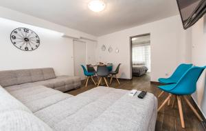 a living room with a couch and a clock on the wall at Apartmani Mabele in Pag