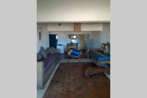 a living room with two couches and a table at Casa Alegria Tofo Beach in Inhambane