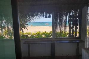a window with a view of the beach and the ocean at Casa Alegria Tofo Beach in Inhambane