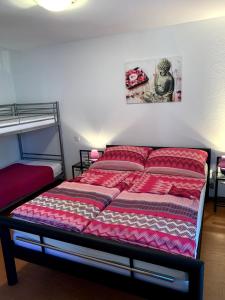 - un lit avec une couette rouge dans une chambre dans l'établissement Gästehaus Nikita, à Rust