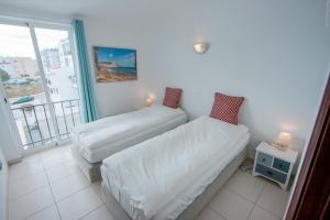 a room with two beds and a window at Apartamento Luztur in Luz