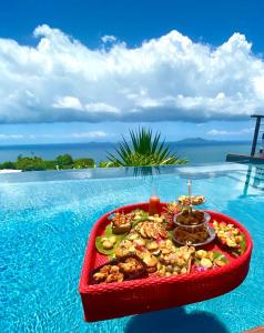 a tray of food sitting in the middle of a swimming pool at Villa Cajou chambres d'hôtes chez l'habitant et Zanzibar cottage in Trois-Rivières