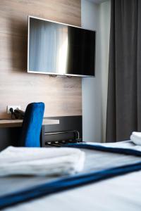 sypialnia z łóżkiem z telewizorem na ścianie w obiekcie Gold Hotel w mieście Złotoryja