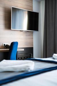 a bedroom with a bed with a tv on the wall at Gold Hotel in Złotoryja