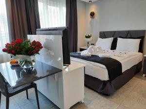 um quarto de hotel com uma cama e uma mesa com flores em Ararat Apart em Istambul