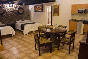 a room with a kitchen and a table and a bed at Hotel Suites Sofia in Querétaro