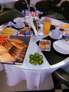 una mesa blanca con comida y bebidas. en Hotel Amália, en São Paulo