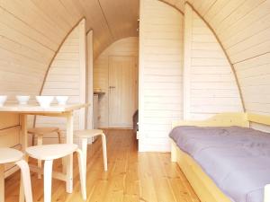 a bedroom with a bed and a table and chairs at Camping du Staedly in Roeschwoog