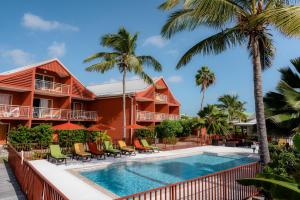 uma vista para um resort com uma piscina e palmeiras em PALM COURT RESIDENCE 4 Stars em Orient Bay