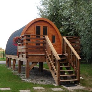 une grande cabane en bois avec un escalier et un toit dans l'établissement Camping du Staedly, à Roeschwoog