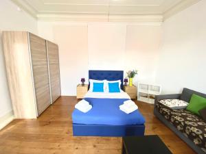 1 dormitorio con 1 cama azul y 1 sofá en Chiado Central Guest House Lisbon Room Classic with shared bathroom, en Lisboa