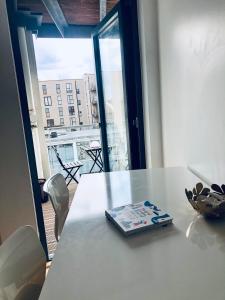 a book on a table with a view of a balcony at Double Room with Private Balcony in London
