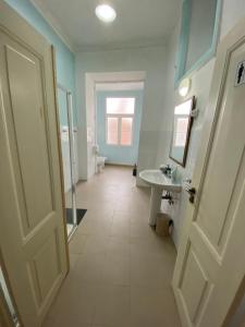 baño con aseo, lavabo y puerta en Chiado Central Guest House Lisbon Room Classic with shared bathroom, en Lisboa