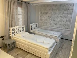 a bedroom with two beds and a window at Le Каприз in Khmelʼnytsʼkyy
