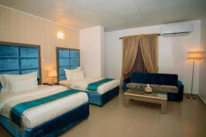 Riviera Suites في لاغوس: غرفة فندقية بسريرين واريكة