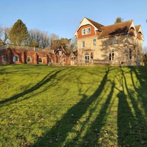 a large house with a long shadow on a field at Country Manor House with indoor pool and hot tub in Rochester