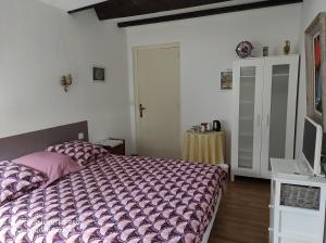 - une chambre avec un lit et une couette violette dans l'établissement Chez Charlotte et Michel, à Brassac