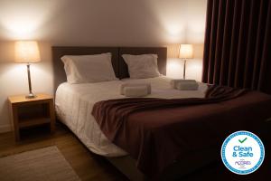 a bedroom with a large bed with two lamps at Casa da Relva in Ponta Delgada