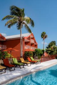 a resort with a pool and chairs and palm trees at Orient Bay Palm Court Residence 4 Stars in Orient Bay