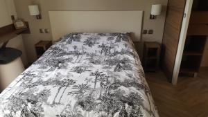 迪纳尔Côte d'Émeraude Mobilhome的一间卧室配有一张带黑白毯子的床