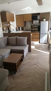 a living room with a couch and a kitchen at Domaine du bois d amour in Dinard