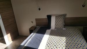 - une chambre avec un lit doté d'une tête de lit en bois dans l'établissement Domaine du bois d amour, à Dinard