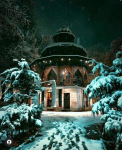 a building covered in snow at night at Bascarsija's Sights in Sarajevo