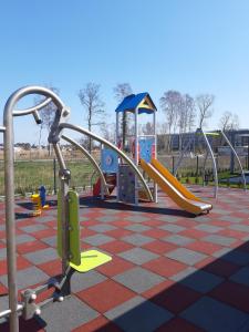 a playground with a slide in a park at Yellow House Dziwnów in Dziwnów