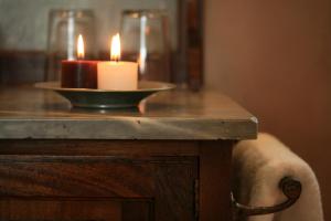 a candle on a table with a bowl with two lit candles at Liodentra in Kardamili