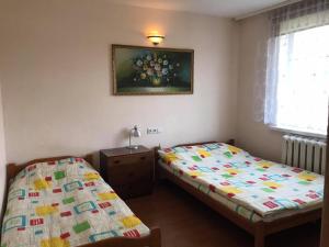 a bedroom with two beds and a picture on the wall at Rooms for Rent near Vilnius in Bezdonys