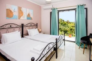 a bedroom with two beds and a large window at Aella Apartment in Skala Kefalonias