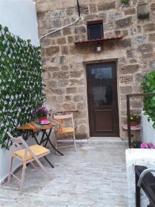 patio ze stołem i krzesłami przed budynkiem w obiekcie Traditional Stone house w mieście Rodos