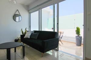 a living room with a black couch and a table at Phaedrus Living: Seaside Luxury Flat Lighthouse 62 in Paphos