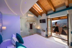 um quarto com uma cama roxa e uma varanda em Donna Sofi Holiday House em Agerola