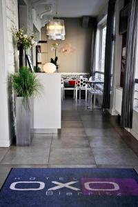 - un hall d'un magasin avec un comptoir et un tapis au sol dans l'établissement Hôtel Oxo, à Biarritz