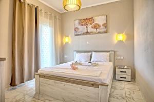 a bedroom with a large bed with white sheets at Villa Ventus in Chortáta
