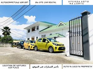 a group of three cars parked in front of a house at Oceanic View Apartments in Beau Vallon