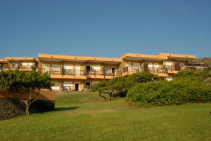 ein großes Gebäude mit Balkonen und Bäumen auf einem Feld in der Unterkunft Residence Hotel La Pelosetta in Stintino